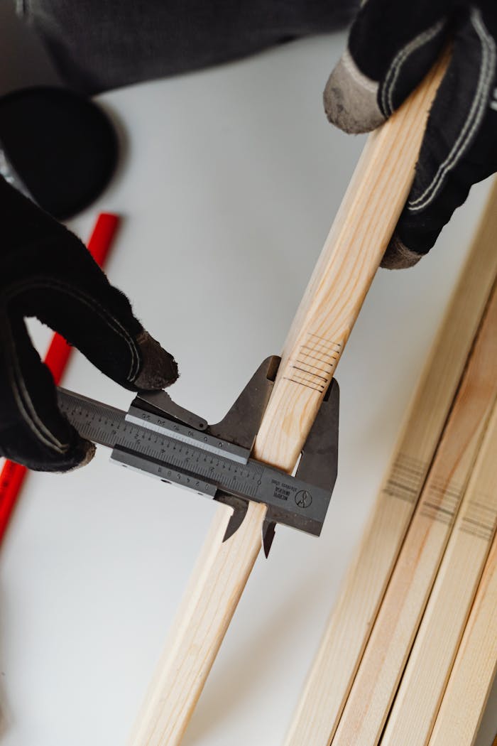 Close-up of a carpenter using a caliper on woodwork, highlighting precision tools.